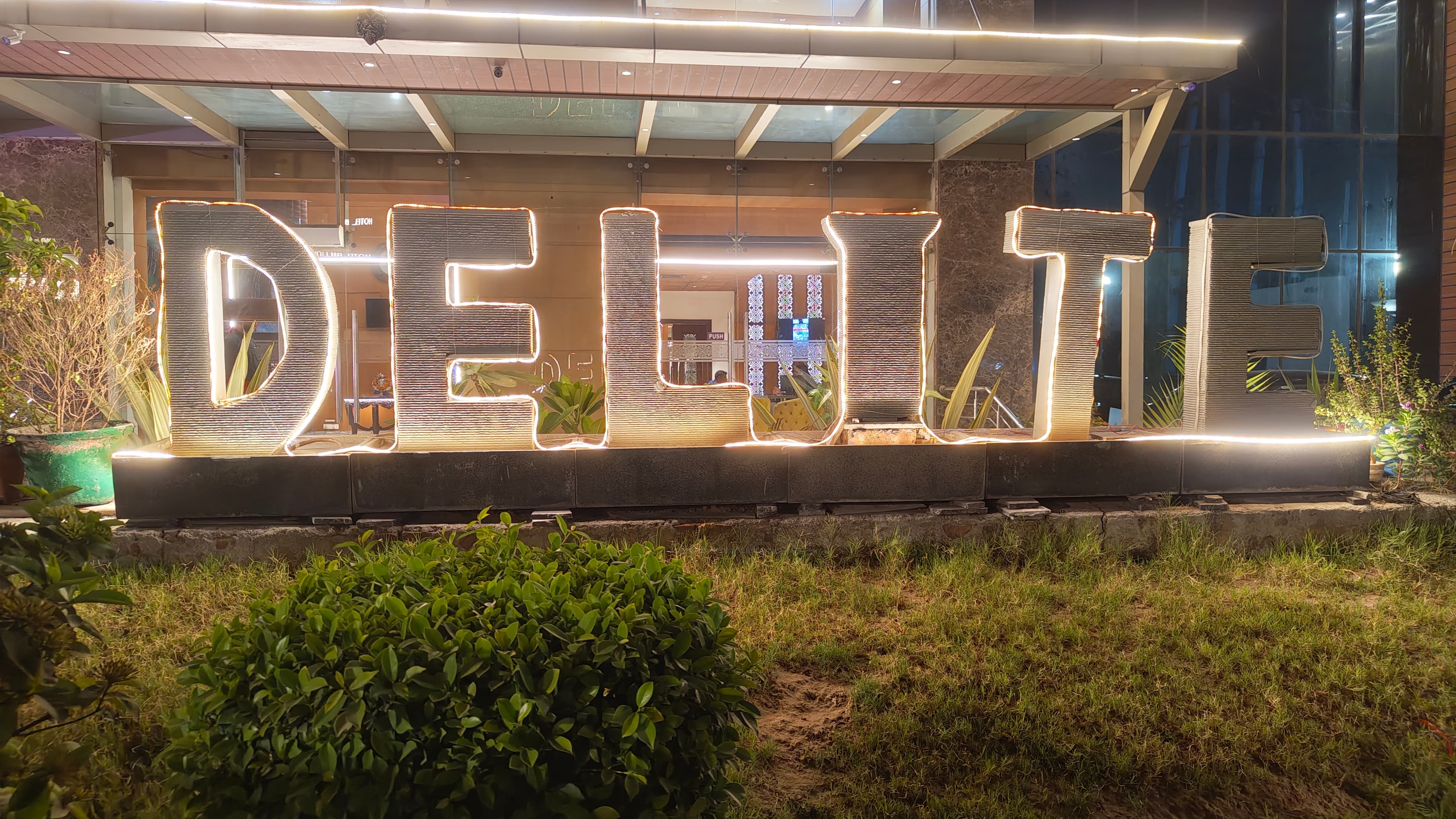 Illuminated Delite Grand signage at the hotel entrance
